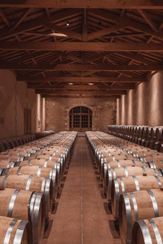 an empty wine cellar with rows of wine barrels at Château Laffitte Carcasset in Saint-Estèphe