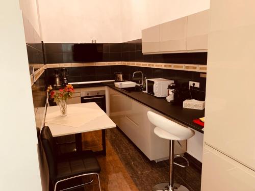 a kitchen with white cabinets and a black counter top at Casa Central Luxury in Oradea