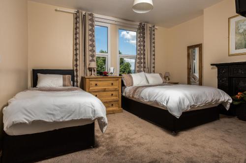 a bedroom with two beds and a window at The Albert in Disley