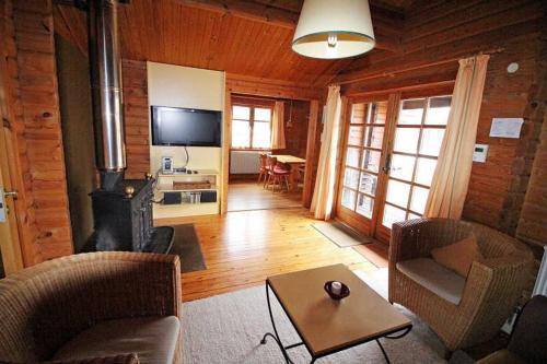 a living room with a couch and a fireplace in a cabin at Ferienpark Lauterdörfle 9 in Hayingen