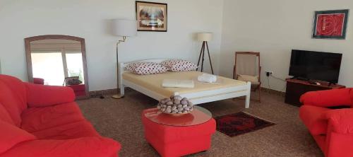 - un salon avec un lit et un canapé rouge dans l'établissement Apartman Ivan, à Mandre