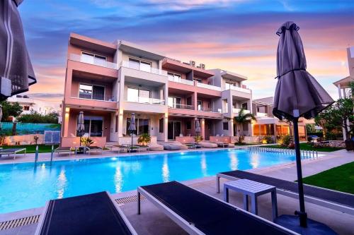 a swimming pool with an umbrella in front of a building at Relax Hotel in Palaiochóra