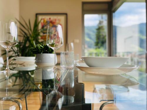 a glass table with plates and wine glasses on it at Villa Maria in Rablà
