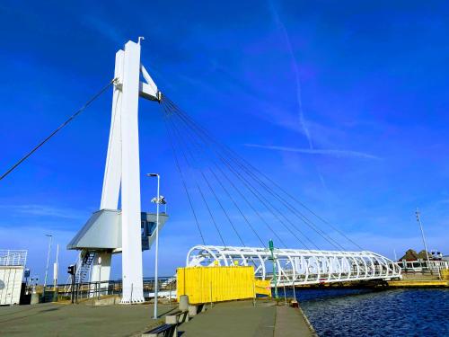a bridge over a body of water with a blue sky at A Morze Ustka in Ustka