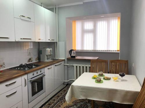 a kitchen with a table with a white table cloth on it at Downtown Homestay in Bishkek