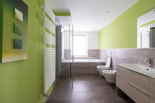 baño con paredes verdes, aseo y lavamanos en Albergo Monte Giove, en Cadarese