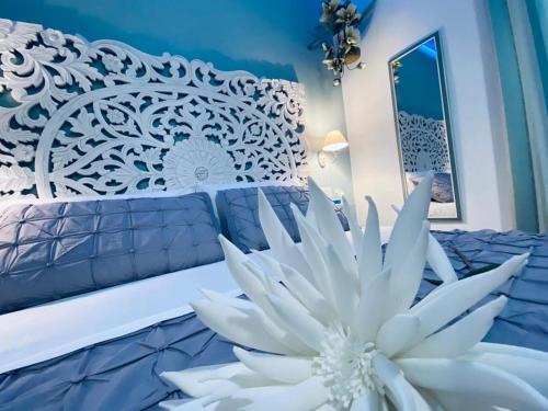 a white flower sitting on top of a bed at Fior dei Carmeliti Rooms and Parking in Tropea