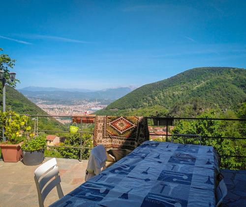 uma mesa azul e cadeiras numa varanda com montanhas em La Valle degli Orti em La Spezia