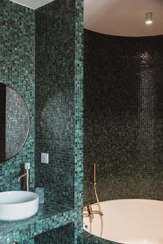 a bathroom with a tub and a sink and a mirror at Château Laffitte Carcasset in Saint-Estèphe