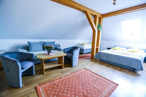 a room with a bed and a couch and a table at Villa Nadmorska Łeba Centrum in Łeba