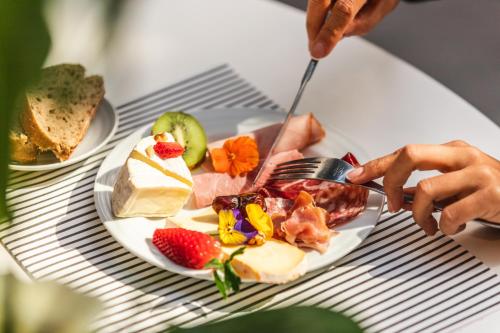 a person eating a plate of food on a table at Novotel Toulouse Centre Wilson in Toulouse
