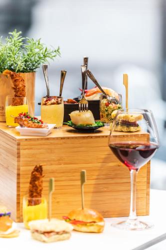 a glass of wine sitting next to a table with food at Novotel Toulouse Centre Wilson in Toulouse