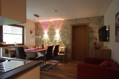 cocina y sala de estar con mesa y sillas en Hirschstube, en Ischgl
