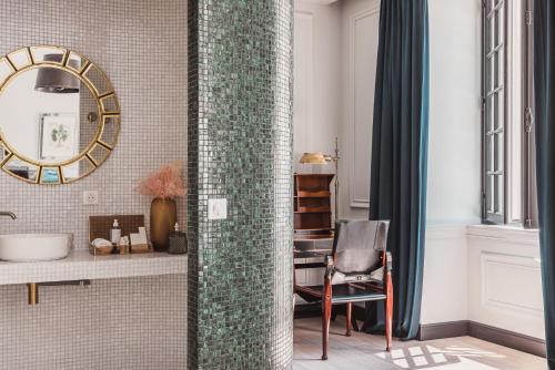 a bathroom with a mirror and a chair at Château Laffitte Carcasset in Saint-Estèphe