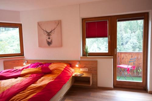ein Schlafzimmer mit einem Bett in einem Zimmer mit Fenstern in der Unterkunft Hirschstube in Ischgl