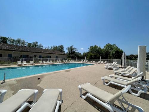 eine Gruppe von Liegestühlen und einem Pool in der Unterkunft Studio 14 - LES SUITES DE ROBINSON - Résidence avec piscine en bord de Siagne, à Mandelieu-La-Napoule in Mandelieu-la-Napoule