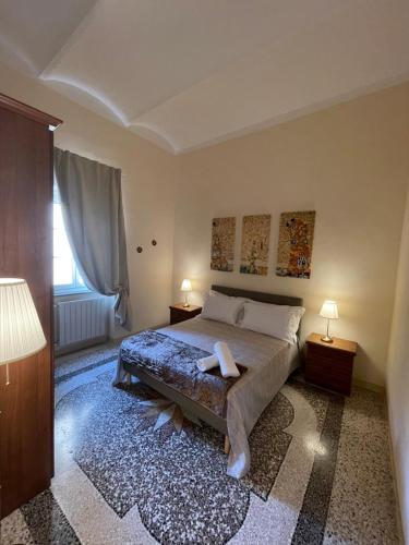 een slaapkamer met een bed, 2 lampen en een raam bij Intero appartamento 3 letti con garage gratuito in Livorno