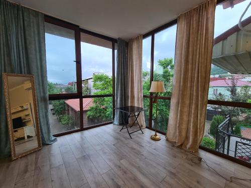a large room with large windows and a table and a mirror at Batumi Wonderland in Batumi