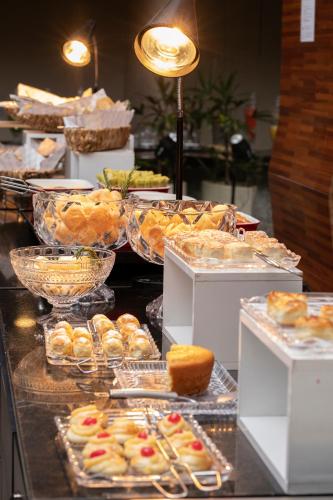a buffet of pastries and other pastries on display at SJ Premium Hotels By Atlantica in Goiânia