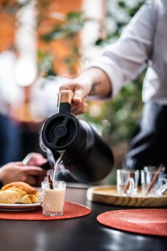 a person pouring a drink into a glass on a table at SJ Premium Hotels By Atlantica in Goiânia