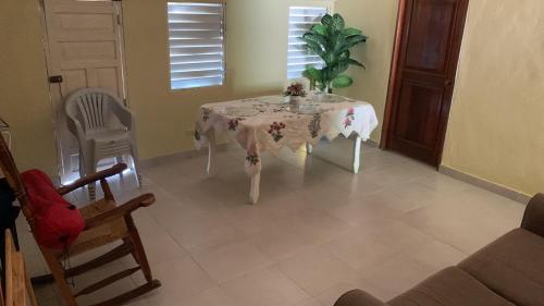 a dining room with a table and chairs and a plant at La Casita de Mary in Santa Cruz de Barahona