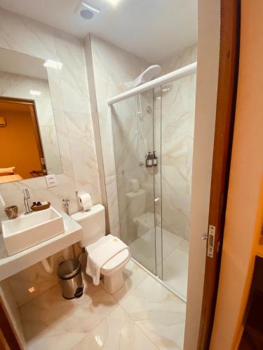 a bathroom with a shower and a toilet and a sink at Beach Eco Stays Hotel Boutique Lagoinha in Tigre