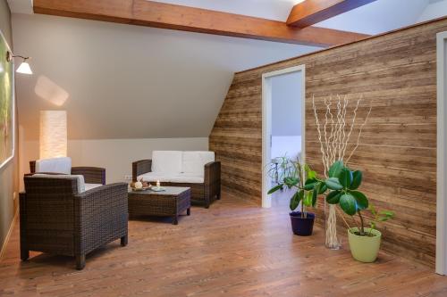 a living room with a wooden accent wall and furniture at Ferien Hotel Spreewald in Kolkwitz