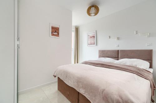a white bedroom with a large bed with white pillows at Apartament 2000 Stare Miasto bulwary Apartamenty No 1 in Szczecin