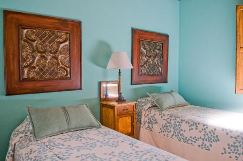 two beds in a room with blue walls at Posada Verde Oliva in Maipú