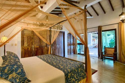 ein Schlafzimmer mit einem Himmelbett in einem Zimmer in der Unterkunft Adventure House Conchas Chinas in Puerto Vallarta