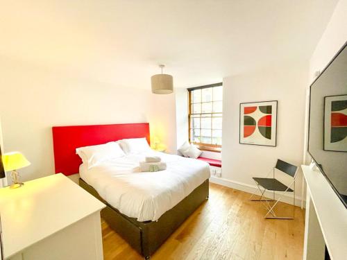 a bedroom with a red and white bed and a desk at Prime Edinburgh New Town. Newly reno'd cosy nest in Edinburgh