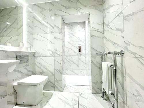 un bagno bianco con wc e doccia di Prime Edinburgh New Town. Newly reno'd cosy nest a Edimburgo