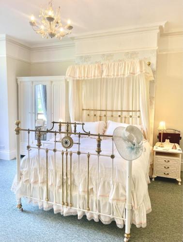 a bedroom with a white bed with a white canopy at The Buckley Arms in Dinas Mawddwy