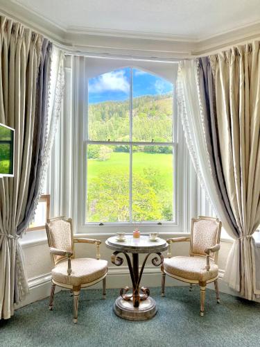 a room with a table and chairs and a large window at The Buckley Arms in Dinas Mawddwy