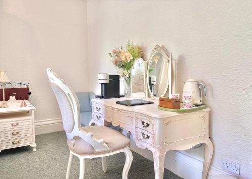a white desk with a mirror and a chair at The Buckley Arms in Dinas Mawddwy