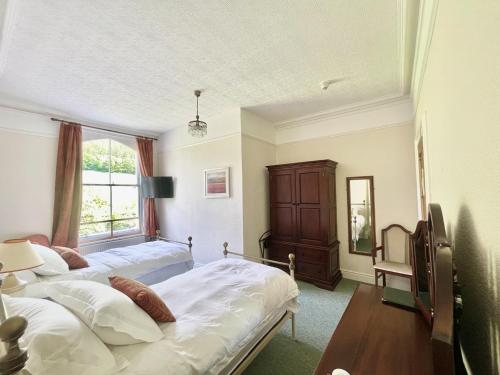 a bedroom with two beds and a window at The Buckley Arms in Dinas Mawddwy