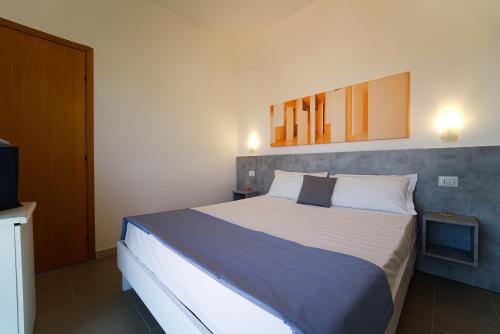 a bedroom with a large bed and a television at Hotel Rivabella in Davoli