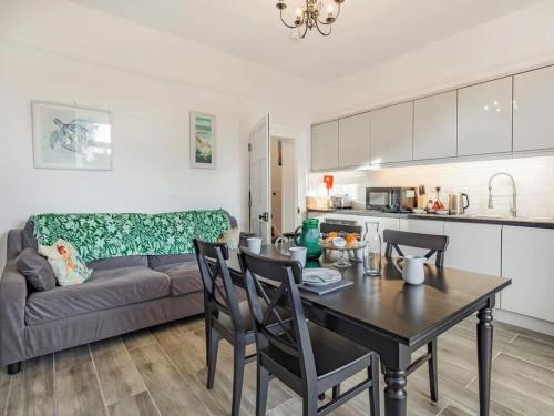 uma cozinha e sala de estar com uma mesa e um sofá em Lovely Villa1king 2 double 4 single 1 bunk beds em Torquay