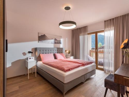 ein Schlafzimmer mit einem großen Bett und einem Balkon in der Unterkunft Apartment Liebelei am See - Kaiserblick, nah am Wasser und neuerbaut in Walchsee