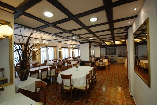un comedor con mesas y sillas en una habitación en Balasca Hotel en Athens