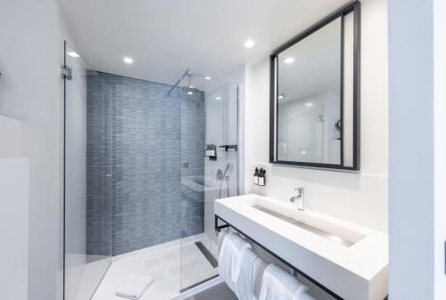 a bathroom with a sink and a glass shower at Hotel Indigo Cagnes-sur-Mer by IHG in Cagnes-sur-Mer