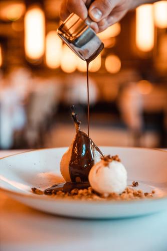 a person taking a picture of a dessert on a plate at Novotel Toulouse Centre Wilson in Toulouse