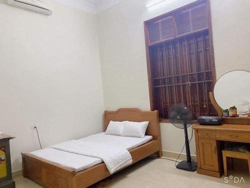 a bedroom with a bed and a desk and a mirror at Homestay hải tiến 25 in Thanh Hóa
