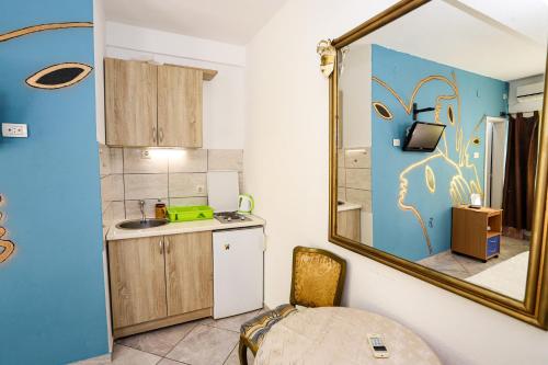 a small kitchen with a sink and a mirror at Guest House Topla in Herceg-Novi
