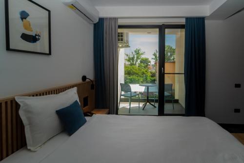 1 Schlafzimmer mit einem Bett und einem Balkon mit einem Tisch in der Unterkunft Hotel Vigo, Eforie Nord in Eforie Nord