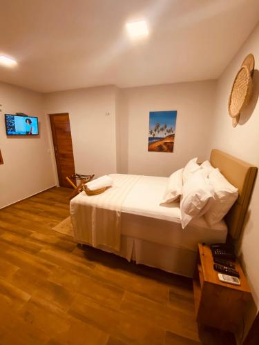 a bedroom with a bed and a tv on the wall at Beach Eco Stays Hotel Boutique Lagoinha in Tigre