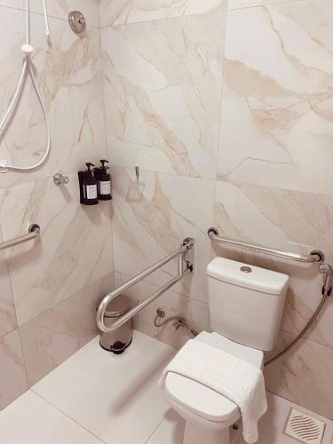a bathroom with a toilet and a marble wall at Beach Eco Stays Hotel Boutique Lagoinha in Tigre