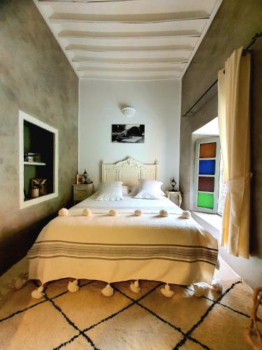 une chambre avec un grand lit dans une pièce dans l'établissement Riad Dar Zouar & Spa, à Marrakech