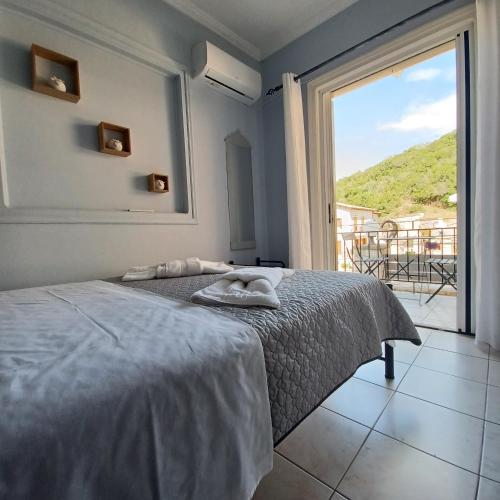 a bedroom with a bed and a large window at Μπουκαμβίλια - Bougainvillea in Sivota