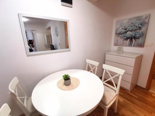 a white dining room with a white table and chairs at Apartment Tatiana in Dubrovnik